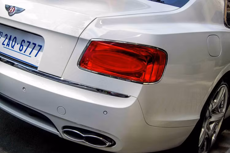 Nhìn tổng thể, chiếc Flying Spur cứng cáp, vuông vắn hơn so với thế hệ tiền nhiệm. Nếu tinh ý sẽ thấy logo bản V8 được sơn màu đỏ, trong khi bản W12 sơn màu đen. 