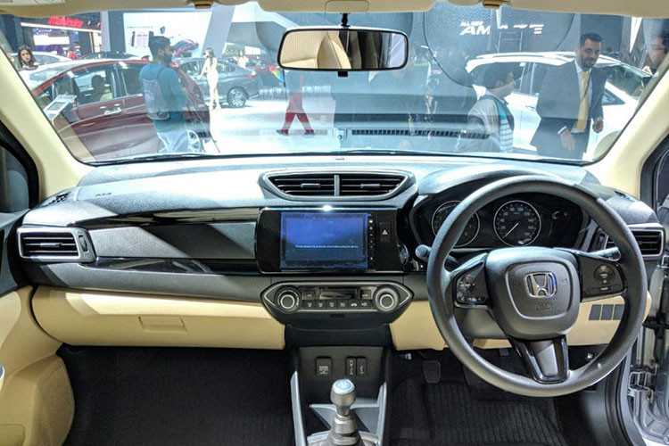 Tương tự ngoại thất, bên trong của Honda Amaze 2018 cũng có không ít điểm mới. Hãng Honda đã trang bị 2 đồng hồ dạng analogue và một màn hình MID nhỏ ở giữa cho Amaze 2018. Tiếp đến là vô lăng đa chức năng 3 chấu, mặt táp-lô tái thiết kế, cụm điều khiển trung tâm, cửa gió điều hòa và hệ thống thông tin giải trí với màn hình cảm ứng mới.