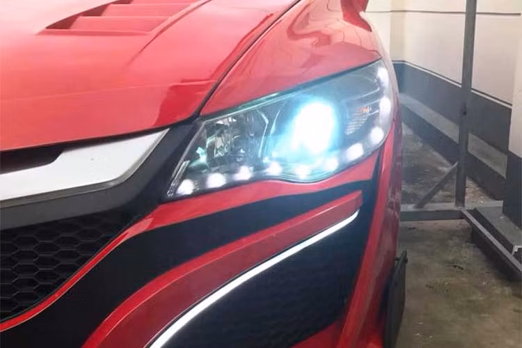 So với chiếc siêu xe NSX thật, bản độ này còn "ưu việt" hơn khi có thêm cặp đèn sương mù LED đầy hấp dẫn. Bên cạnh đèn sương mù, bộ đèn pha nguyên bản của Civic cũng đã được chế thêm các bóng LED nhỏ, tạo thành hàng "mí mắt" ở phía dưới. Để tăng tính thể thao cho chiếc xe, nắp ca-pô với các khe thoát nhiệt đã được bổ sung thêm cho Civic.