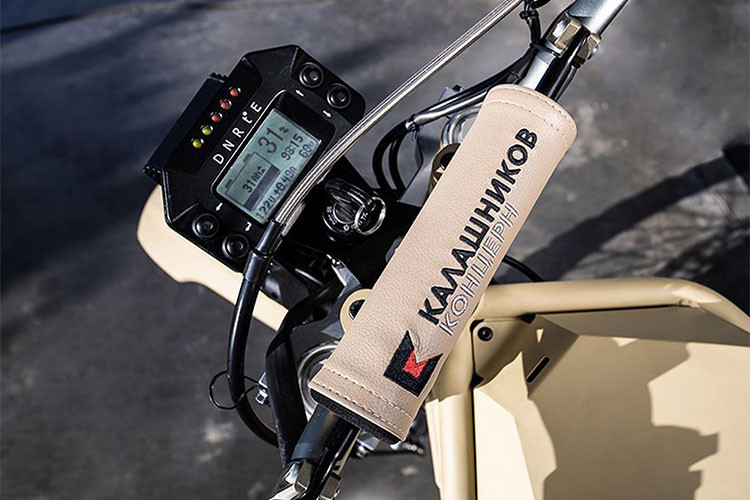 Trong khi đó, mẫu Kalashnikov SM-1 2018 là phiên bản đặc biệt dành cho quân đội, đã từng xuất hiện trong đoạn video quảng cáo của công ty này vào năm 2017. Khác với phiên bản cho cảnh sát, phiên bản cho quân đội có bộ cánh màu cát "Desert Camo" để phù hợp hơn cho thương mại.