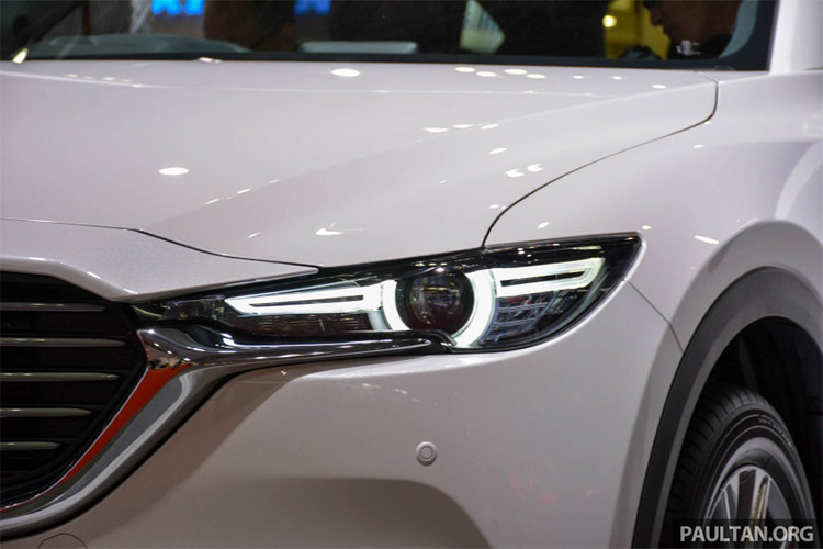 Về thiết kế ngoại thất ngoài kíh thước lớn hơn, có thể dễ dàng nhận thấy CX-8 phiên bản mới được thừa kế nhiều chi tiết từ "người anh em" CX-5, dễ nhận thấy nhất là kiểu dáng đèn chiếu sáng trước và sau xe được vuốt mỏng sang hai bên, lưới tản nhiệt miệng cười đặc trưng.