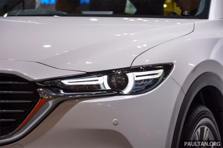 Về thiết kế ngoại thất ngoài kíh thước lớn hơn, có thể dễ dàng nhận thấy CX-8 phiên bản mới được thừa kế nhiều chi tiết từ "người anh em" CX-5, dễ nhận thấy nhất là kiểu dáng đèn chiếu sáng trước và sau xe được vuốt mỏng sang hai bên, lưới tản nhiệt miệng cười đặc trưng.