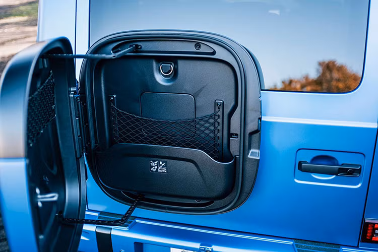 Điểm khác biệt đáng chú ý là phía sau xe SUV điện Mercedes-Benz G580 không còn lốp dự phòng mà thay vào đó là hộp đựng cáp sạc. Điều này vừa tối ưu không gian vừa thể hiện rõ ràng tính hiện đại của dòng xe mới.