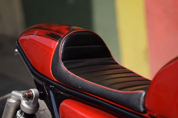 Dàn vỏ đuôi nguyên bản trên chiếc CB400 độ cafe racer này cũng đã bị loại bỏ hoàn toàn, và sau đó Hendra đã chỉnh lại phần khung phụ phía sau đuôi xe. Nằm phía trên khung phụ mới là chiếc yên solo với "gò" nổi khí động học đúng theo dáng cafe racer.