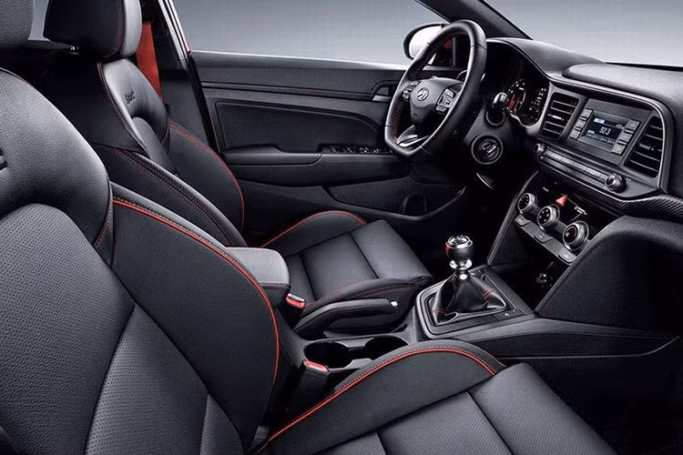 Bên trong Hyundai Elantra Sport 2019 cũng có những đặc điểm nhận dạng như nội thất bọc da màu đỏ hoặc đen, vô lăng chữ D thể thao (tích hợp lẫy chuyển số ở bản dùng hộp số tự động ly hợp kép) và bảng đồng hồ riêng.