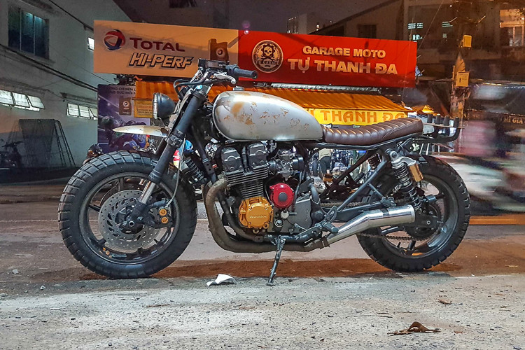 Bản độ của mẫu xe môtô Honda CB750F đời cũ này được xưởng garage Tự Thanh Đa “cover” theo đúng phong cách bộ đôi xế độ trong siêu phẩm bom tấn The Walking Dead, với vẻ bề ngoài không thể chất hơn. Nét bụi bặm và độ ngầu của xe được thể hiện qua màu sơn rỉ sét của bình xăng lớn, đèn pha đặt lệch cùng chi tiết ở baga phía sau…