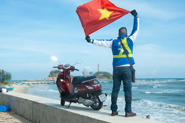 Một shot hình đẹp ghi lại hình ảnh của biker đến từ Hà Nội với lá cờ tổ quốc trên tay hướng về phía ngọn hải đăng Kê Gà.