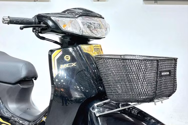 Honda Dream 125 NCX 2024 bản Campuchia sở hữu phần đầu với cụm đèn chiếu sáng và đèn hậu to bản dạng halogen, hai bên là đèn báo rẽ. Phía trước có giá gắn giỏ xe - chi tiết biến mất trên những chiếc xe máy phổ thông tại thị trường Việt Nam hiện nay.