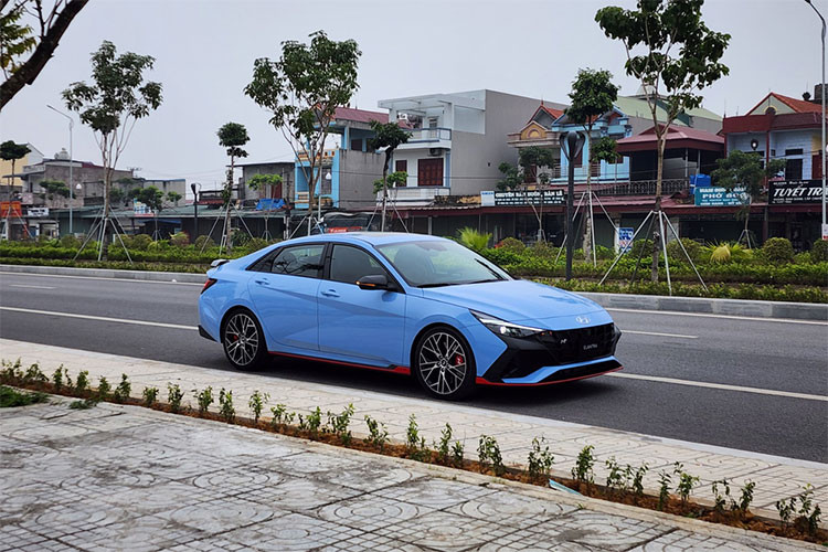 Chiếc xe sedan Hyundai Elantra N 2023 tại Việt Nam này sở hữu ngoại thất màu xanh bắt mắt, thời thượng. Phần đầu xe gây ấn tượng với mặt ca lăng và hốc gió trước hầm hố, thể thao hơn. Xe được trang bị dàn nhựa để chia cách lưới tản nhiệt và 3 hốc gió. Bên canh đó, xe có thêm 1 cánh lướt gió trước và bên hông. Lazang của xe được trang bị loại 19 inch với 2 màu tương phản nổi bật.