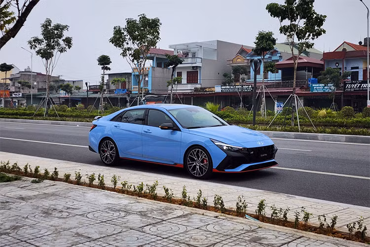 Chiếc xe sedan Hyundai Elantra N 2023 tại Việt Nam này sở hữu ngoại thất màu xanh bắt mắt, thời thượng. Phần đầu xe gây ấn tượng với mặt ca lăng và hốc gió trước hầm hố, thể thao hơn. Xe được trang bị dàn nhựa để chia cách lưới tản nhiệt và 3 hốc gió. Bên canh đó, xe có thêm 1 cánh lướt gió trước và bên hông. Lazang của xe được trang bị loại 19 inch với 2 màu tương phản nổi bật.