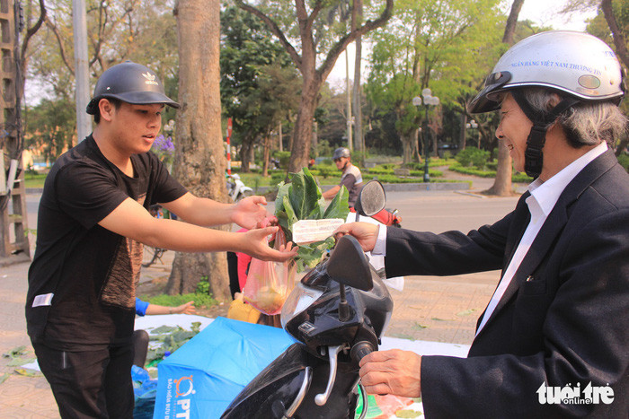 Giờ tan tầm, rất đông người dân thủ đô đến các địa điểm "giải cứu" mua giúp bà con nông dân - Ảnh: HÀ THANH