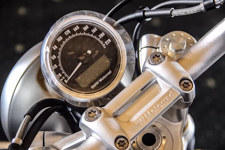  Cụm đồng hồ thiết kế dạng tròn cổ điển, nhỏ - với kim hiển thị vận tốc và được bố trí màn hình điện tử phía dưới. Bên cạnh đó, vị trí lái cũng đã được chỉnh sửa đáng kể với tay lái rộng và cao hơn so với "người anh em" R NineT của mình.