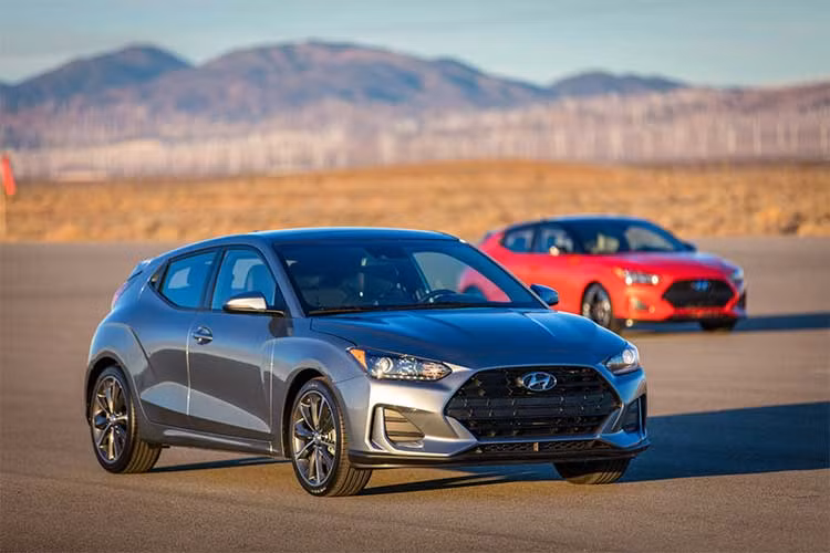 Những đường gân nổi ở xung quanh vòm bánh cùng sơn 2 tông màu khiến Veloster nổi bật hơn khi nhìn từ hai bên thân xe. Ở phía sau, điểm nhấn nổi bật nhất của chiếc xe là cặp đèn hậu với các dải LED hình mũi tên. Bộ cản sau cũng có thiết kế rất ấn tượng với cánh khuếch tán không khí ốp bên dưới và ống xả kép đặt chính giữa.