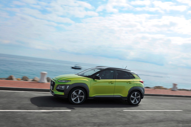 Bên sườn Hyundai Kona 2018 xuất hiện nẹp nhựa màu đen xung quanh hốc bánh, mang đến vẻ rắn rỏi và đậm chất SUV. Những điểm nhấn khác trong thiết kế ngoại thất của mẫu xe Hàn Quốc này bao gồm cánh gió mui nổi bật, giá nóc, cụm đèn hậu nằm cao trong khi đèn báo lùi và báo rẽ gắn vào những chi tiết bằng nhựa màu đen ở đuôi xe...