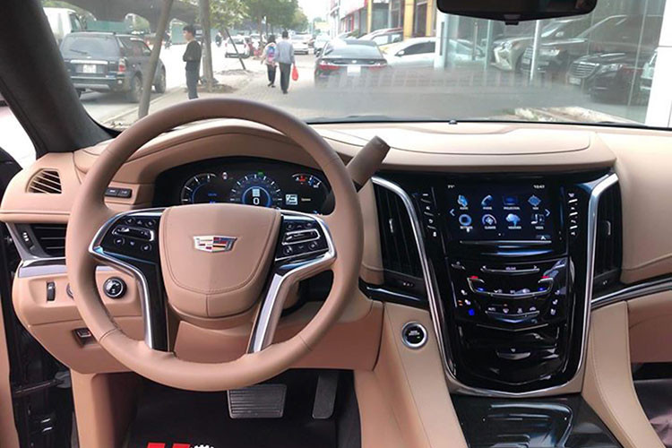 Toàn bộ khoang nội thất của chiếc Cadillac Escalalde Platinum 2019 này đều được bọc da Nappa. Vô-lăng 4 chấu bọc da ốp gỗ tích hợp rất nhiều phím chức năng hỗ trợ người lái, phía sau bên phải là cần số. Màn hình hiển thị thông tin dạng điện tử thiết kế rất đẹp mắt. Xe còn được trang bị màn hình HUD hiển thị trên kính.