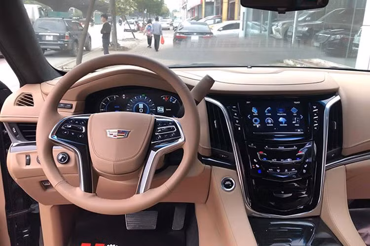 Toàn bộ khoang nội thất của chiếc Cadillac Escalalde Platinum 2019 này đều được bọc da Nappa. Vô-lăng 4 chấu bọc da ốp gỗ tích hợp rất nhiều phím chức năng hỗ trợ người lái, phía sau bên phải là cần số. Màn hình hiển thị thông tin dạng điện tử thiết kế rất đẹp mắt. Xe còn được trang bị màn hình HUD hiển thị trên kính.