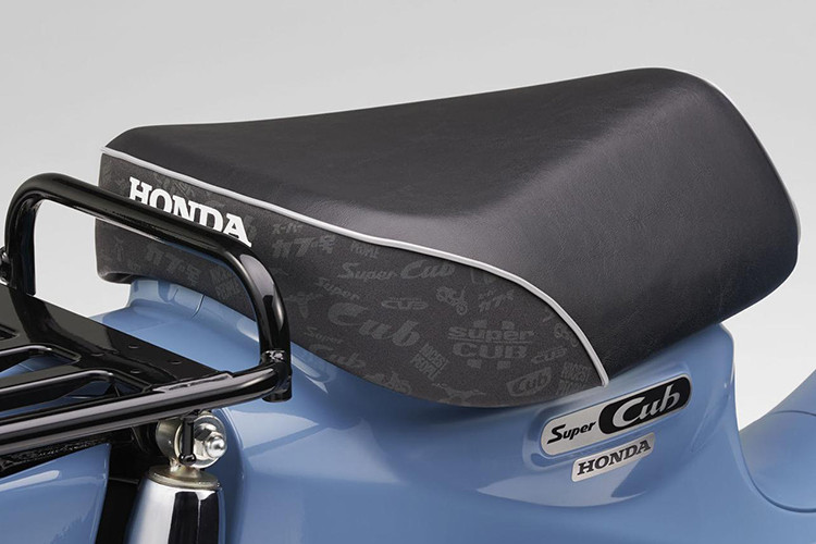 Chiếc xe vẫn giữ nguyên bộ yên đơn và giá đèo hàng bằng kim loại sơn tĩnh điện màu đen giống như truyền thống của dòng xe Honda Super Cub huyền thoại. Bên dưới yên xe là logo Super Cub cách điệu được thiết kế mang hơi hướng cổ điển, đẹp mắt trên nền mạ chrome.