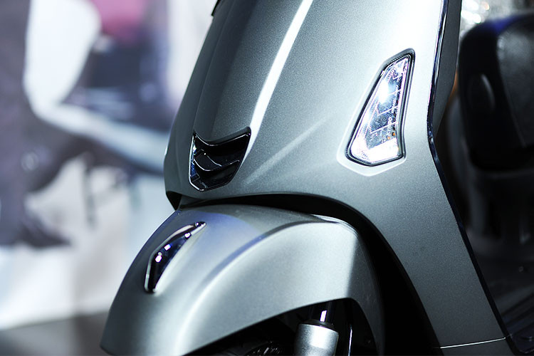 Phần dưới đầu đèn của Like 125 nổi bật biểu tượng chữ V, phía trước vuốt nhọn sắc sảo với cụm đèn định vị LED mới cùng tấm ốp sang bóng, trông cao cấp - tuy nhiên nếu chú ý bạn cũng có thể thấy nó lại khá giống với "đối thủ" đang bán ra của Piaggio Việt Nam là Vespa Primavera.