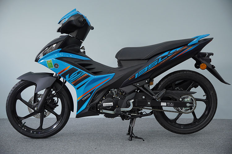 Xe máy Yamaha 135LC Fi 2025 về Việt Nam có hai phiên bản gồm tiêu chuẩn và bản Special Edition (SE). Bản tiêu chuẩn có ba màu sắc: xanh dương Aqua, vàng cát Sandstorm và xanh rêu Moss Green. Thiết kế tổng thể xe vẫn giữ phong cách thể thao quen thuộc. Tuy nhiên, điểm khác biệt nằm ở bộ tem mới với đồ họa và một số tinh chỉnh về trang bị.