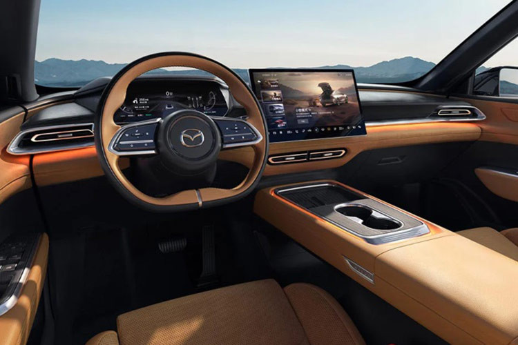 Mazda EZ-6 sở hữu không gian nội thất hiện đại, mang hơi hướng tối giản với hầu hết các nút điều khiển được tích hợp vào màn hình cảm ứng kích thước 14,6 inch đặt giữa mặt taplo. Trong khi đó, vô-lăng và bảng đồng hồ kỹ thuật số 10,2 inch có vẻ giống thiết kế trên mẫu Deepal SL03. 