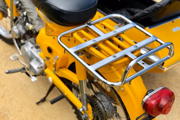 Phía sau xe vẫn là giá đèo hàng bằng kim loại sáng bóng - phong cách của dòng xe máy Honda Super Cub trải qua hơn 100 năm có mặt trên thị trường thế giới. Khóa điệnh của xe được đặt bên cốp trái.