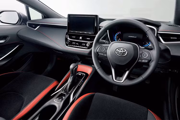 Bên trong nội thất, Corolla Sport cũng được giữ nguyên so với bản Mỹ với thiết kế tối giản, cùng với hệ thống thông tin giải trí với màn hình 7 inch đặt thẳng đứng trên táp-lô. Đúng như tên gọi, Toyota đã khiến cabin trên chiếc xe mang phong cách thể thao hơn nhờ có cặp ghế ngồi ôm lưng, cũng như nội thất bọc 2 tông màu đỏ-đen đầy kích thích.