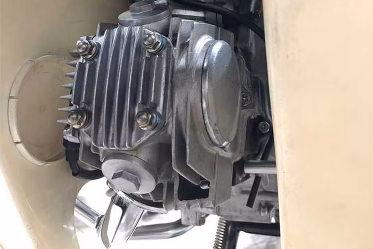 Bên dưới gầm xe, thân máy và cần khởi động của chiếc xe này cũng hoàn toàn sạch sẽ không hề dính bùn đất hay dầu mỡ. Bưởng máy của chiếc Dream này vẫn còn mới tinh, hoàn toàn không có một vết xước và lấp lánh ánh nhũ bạc như mới rời khỏi nhà máy của Honda Thái Lan.