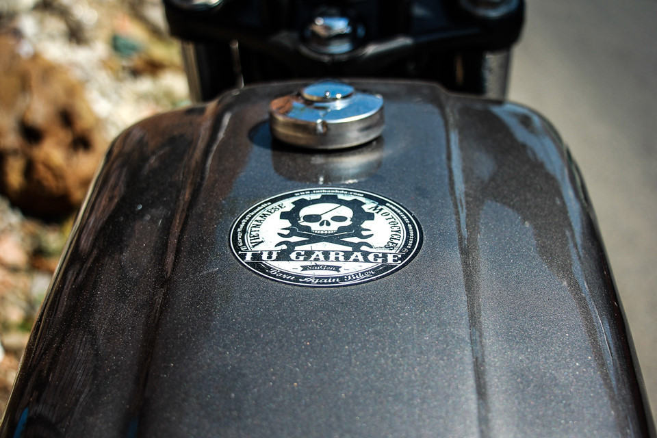 Bình xăng được gò thủ công với đường dập nổi chạy dọc, tăng tính cơ bắp và góc cạnh so với bình xăng nguyên bản.