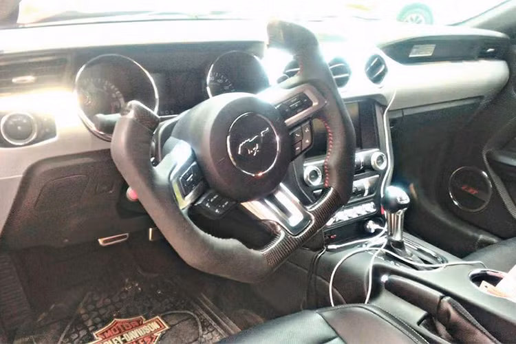 Ngoài việc lắp bộ mâm "hổ mang chúa" có giá lên đến 200 triệu đồng và một số chi tiết ngoại thất độc đáo, bên trong khoang lái của chiếc Ford Mustang thế hệ thứ 6 cũng được chủ nhân độ lại một chi tiết cũng thuộc diện hàng độc tại Việt Nam chính là vô-lăng Carbon Fiber.