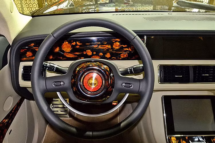 Mang khuynh hướng cổ điển, vô-lăng của Hongqi L5 dạng hình tròn thiết kế khá đơn giản không có đa dạng các nút bấm như nhiều mẫu xe hiện đại đang có trên thị trường. Thêm một màn hình cảm ứng 8 inch ở trung tâm của bảng táp-lô, xung quanh là các chi tiết được ốp gỗ bóng ấn tượng.