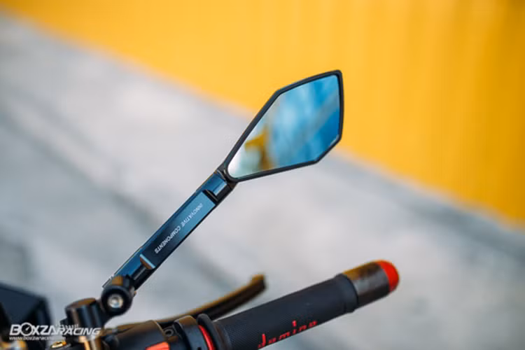 Bên cạnh đó là bao tay và cùm ga Domino, kiếng độ thương hiệu CNC cùng với bình dầu Racingboy thay cho nguyên bản.