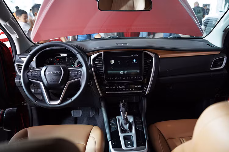 Điểm khác biệt nổi bật nhất của Isuzu MU-X 2022 so với thế hệ trước đã được "lột xác" hoàn ở không gian nội thất, khách hàng có thể chọn màu đen hoặc nâu sang trọng. Hộc để đồ trên taplo đã không còn mà thay vào đó là nút kích hoạt đèn cảnh báo (hazzard) đặt ngay trên màn hình trung tâm.