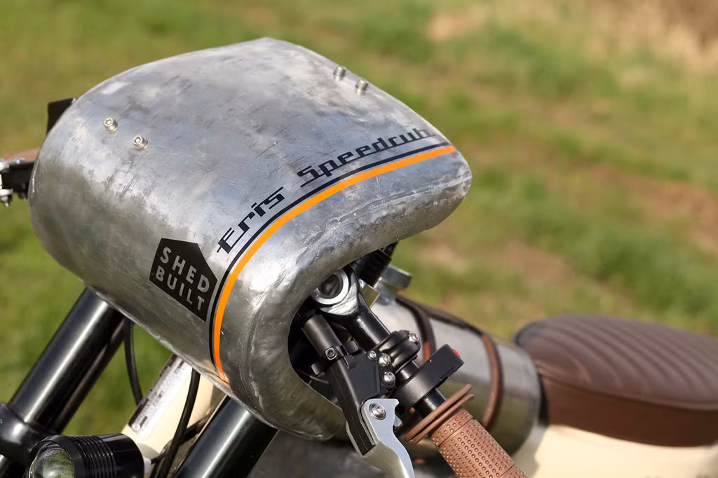 Sau đó, khối động cơ được gắn vào khung sườn của chiếc Cub. Một thanh ngang được hàn thêm vào khung để nâng bình xăng tự chế. Phần đầu đèn được tháo bỏ để lộ cặp phuộc up-side-down, đầu xe hạ thấp cùng cụm ghi đông clip-on khiến người ngồi chồm về trước trong thế núp gió.