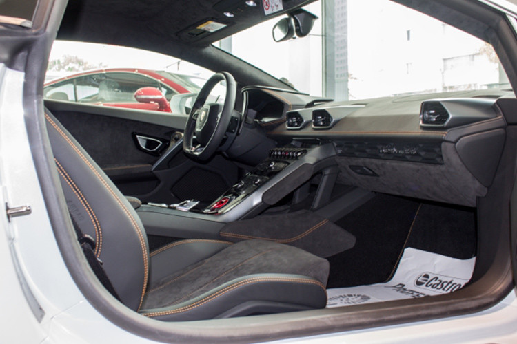 Đối lập với bộ áo trắng Bianco Monocerus, chiếc siêu xe Lamborghini Huracan LP610-4 đang rao bán có nội thất bọc da Alcantara đi kèm các chi tiết may chỉ cam ở ghế ngồi. Xe được trang bị màn hình cảm ứng 8.4 inch được đặt ở trung tâm bảng điều khiển. Màn hình này có thể cảm ứng đa điểm, Apple CarPlay tích hợp, kết nối định vị và hơn thế nữa.