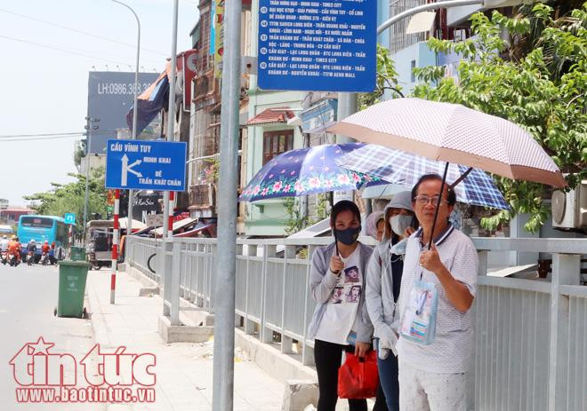 Những người đang đứng đợi xe buýt dưới nắng nóng giữa trưa chẳng khác gì đang chịu cực hình.