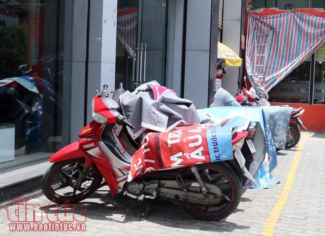 Xe máy cũng được phủ bạt, che đậy để chống nắng.