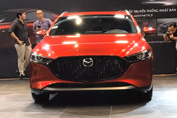 Phần đầu xe của Mazda3 thế hệ mới vừa xuất hiện tại Việt Nam nổi bật với cụm lưởi tản nhiệt màu đen bóng, đèn pha mảnh, bên dưới là những đường cắt mạnh mẽ ở cản trước. Thân xe thon dài đi kèm với các đường gân dập nổi cá tính, kính chắn gió sắc nét. 