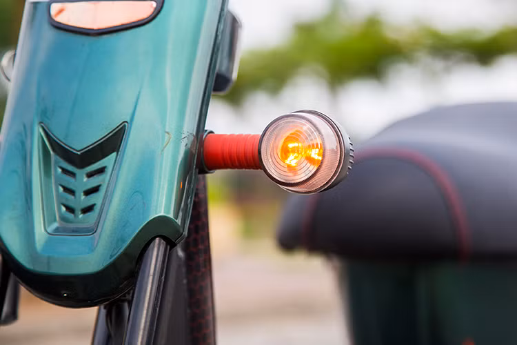 Anbico tách biệt hai cụm đèn chiếu sáng trước ở hai vị trí khác nhau, trên và dưới. Cụm đèn pha dưới nằm gọn trong khung đỡ giỏ xe phía trước trong khi đèn phía trên kiểu cổ điển giống như trên những chiếc xe đạp thế kỷ trước. Hai đèn báo rẽ hình tròn nằm ở khoảng giữa hai cụm đèn chính có khả năng đàn hồi để chống việc gãy vỡ do va chạm.