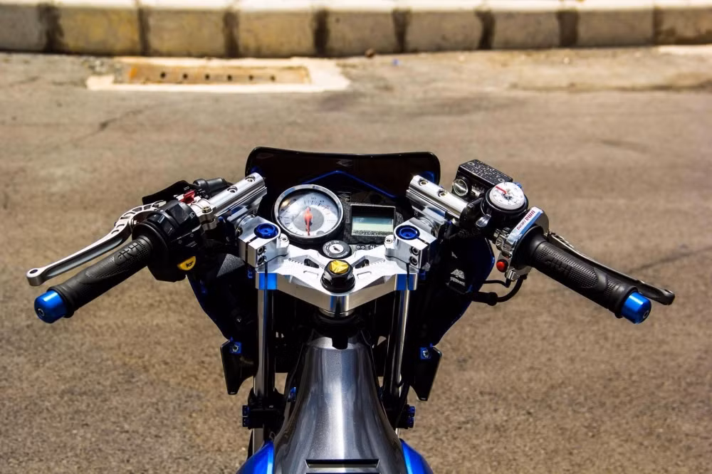 Cụm ghi đông nguyên bản của xe đã được chủ nhân độ lại với phong cách "tay lái gãy" của thương hiệu Racing Boy nổi bật và phong cách.