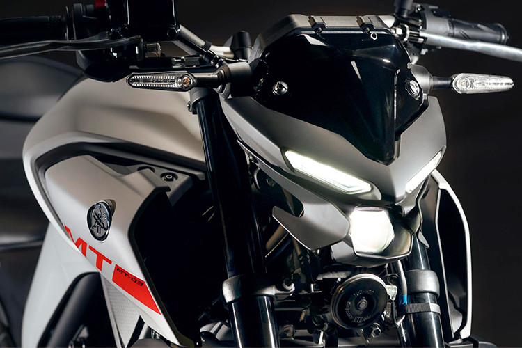 Đèn pha của xe ứng dụng công nghệ LED dạng Projector giúp khả năng gom sáng tốt hơn, phía trên là cặp đèn định vị LED tạo hình như đôi mắt. Hai bên đèn pha của xe có thêm ốp nhựa, giúp tạo cảm giác liền lạc và cứng cáp hơn so với đầu đèn trên Yamaha MT-15. Cặp đèn xinhan trước được bố trí hai bên đầu đèn, có kích thước được thu gọn.