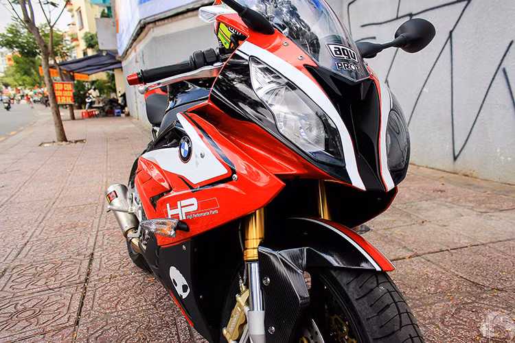 Dàn đầu xe mang màu sắc mới với 3 tông màu đỏ, trắng, đen cùng dàn tem đấu phong cách siêu môtô BMW HP4 cực kỳ ấn tượng. Dè trước nguyên bản của xe đã được chủ nhân làm mới bằng việc ốp carbon fiber đen.