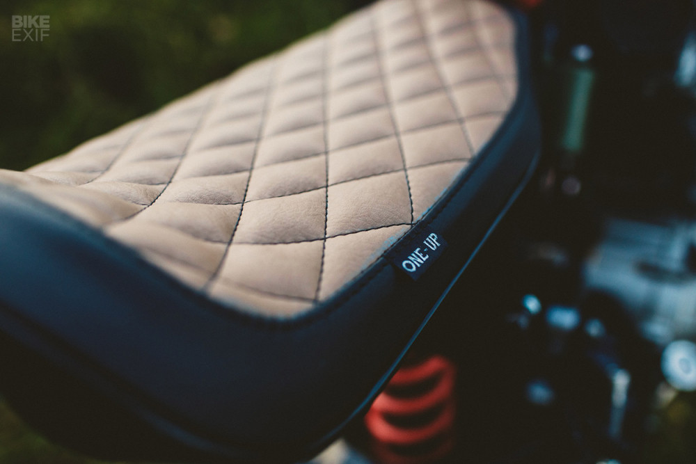 Bộ yên solo được bọc bởi da yên 2 màu theo phong cách cổ điển được One up design thiết kế thủ công riêng cho chiếc Honda CB600F độ cafe racer này. Yên xe với các đường chỉ nổi bật trên các ô dạng lưới mắt cáo.