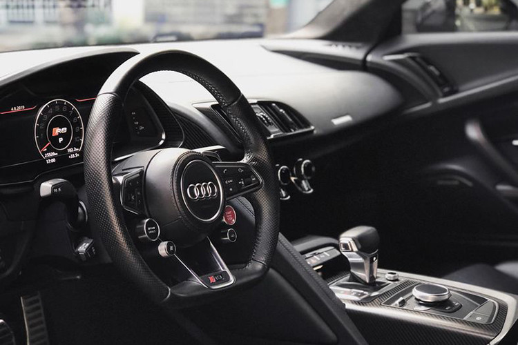 Bên trong xe, tầm nhìn về mọi hướng khá tốt, mặc dù đây là siêu xe động cơ đặt giữa. Lẫy chuyển số đặt ngay sau vô lăng giúp giảm thời gian sang số ở chế độ thể thao. Nội thất vẫn giữ phong cách truyền thống của Audi với da thật và những đường chỉ khâu tay. Sợi carbon bao phủ bệ trung tâm, xung quanh khe gió điều hòa.