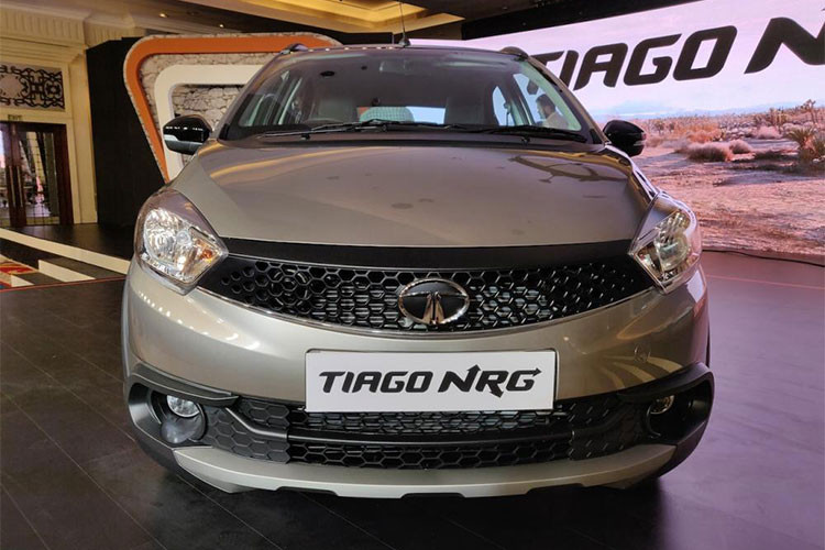 Ngoại hình Tata Tiago NRG cũng cứng cáp hơn nhờ nhiều chi tiết phối với màu đen như toàn bộ ốp thân dưới quanh xe, gương chiếu hậu, cản chống va đập, nóc xe, thanh giằng buộc đồ trên nóc xe, bộ vành hợp kim 14 inch 2 tông màu và các chi tiết hoàn thiện ở cửa cốp.