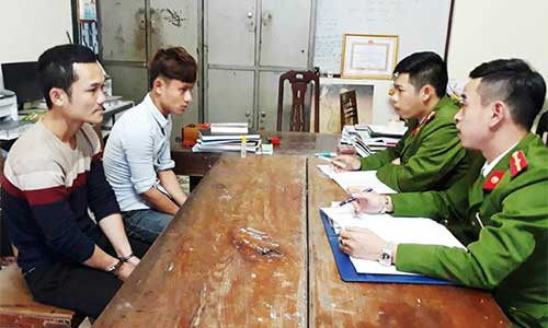 Khoa (áo len) và Dương tại cơ quan công an. Ảnh: P.H.