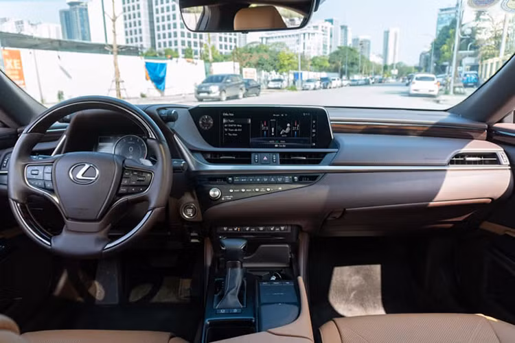 Bước vào khoang lái của Lexus ES 2021 sở hữu vẻ sang trọng của chiếc sedan Nhật Bản không phải kiểu bóng bẩy mà nhẹ nhàng tinh tế, thậm chí có thể dùng từ đơn giản. Cụm điều khiển trung tâm rất ít nút bấm, nổi bật với màn hình giải trí 12.3 inch với tone màu hiển thị chủ đạo là xanh nước biển, đem lại cảm giác êm dịu thư thái.