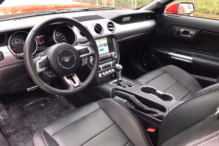 Bước vào không gian nội thất, mẫu xe cơ bắp Ford Mustang Premium 2019 đầu tiên về Việt Nam sở hữu một không gian cabin đầy ấn tượng với thiết kế nam tính và mang một màu đen xuyên suốt. Vô lăng kim loại 3 chấu bọc da, tích hợp nhiều phím chức năng hỗ trợ người lái và lẫy chuyển số phong cách thể thao.