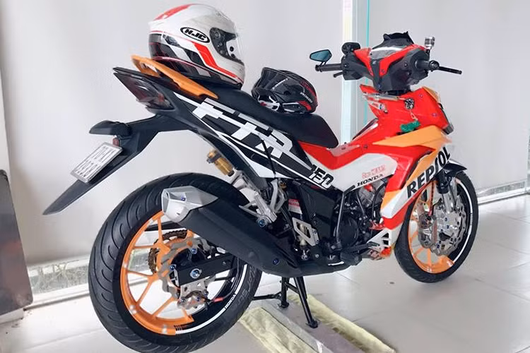 Winner 150 độ đồ chơi hàng hiệu này khoác ngoài bộ cánh đậm chất thể thao với phiên bản Repsol còn được trang bị trợ lực và phuộc bình dầu sau Ohlins. Dàn chân với vành mâm sơn tem đấu 2 màu " cam đen " nổi bật. Hệ thống Upside down đầy cứng cáp, đĩa Galfer lòng nhôm CNC hài hòa cùng heo Brembo M4 Monobloc 108 hàng hiệu.