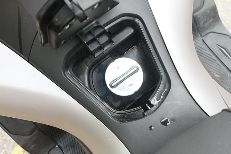 Bên cạnh công tắc của khóa Smart Key là nút bấm để mở yên và nắp bình xăng, trong đó, nắp bình xăng của xe được đặt ở chính giữa khoang để chân, giúp đổ xăng dễ dàng hơn. Hộc phụ chứa đồ phụ cũng dược trang bị lớn hơn phiên bản cũ, nhưng đáng tiếc lại thiếu tiện ích cổng sạc thiết bị di động vốn đang được nhiều hãng xe áp dụng hiện nay.