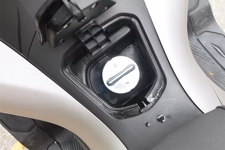 Bên cạnh công tắc của khóa Smart Key là nút bấm để mở yên và nắp bình xăng, trong đó, nắp bình xăng của xe được đặt ở chính giữa khoang để chân, giúp đổ xăng dễ dàng hơn. Hộc phụ chứa đồ phụ cũng dược trang bị lớn hơn phiên bản cũ, nhưng đáng tiếc lại thiếu tiện ích cổng sạc thiết bị di động vốn đang được nhiều hãng xe áp dụng hiện nay.